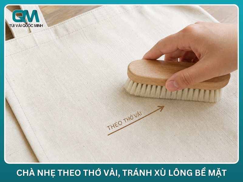 bàn chải lông mềm chà nhẹ theo thớ vải trên bề mặt túi canvas