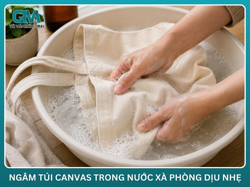 túi vải canvas đang được giặt tay nhẹ nhàng trong chậu nước xà phòng