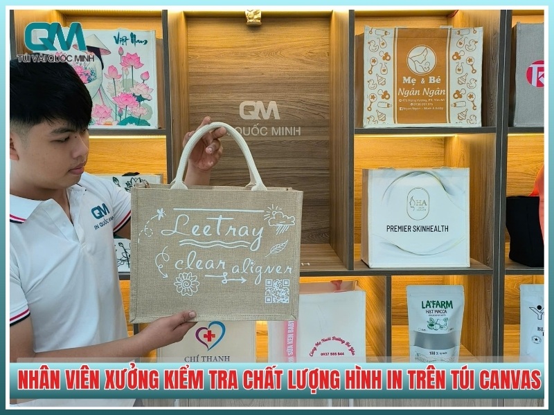 nhân viên xưởng kiểm tra chất lượng hình in trên túi canvas