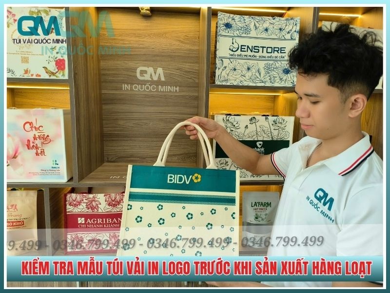 nhân viên tư vấn kiểm tra mẫu túi vải in logo trước khi sản xuất hàng loạt