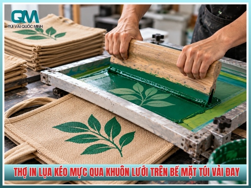 thợ in lụa kéo mực qua khuôn lưới trên bề mặt túi vải đay