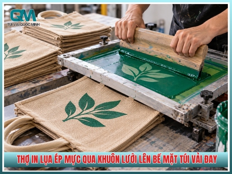 thợ in lụa ép mực qua khuôn lưới lên bề mặt túi vải đay
